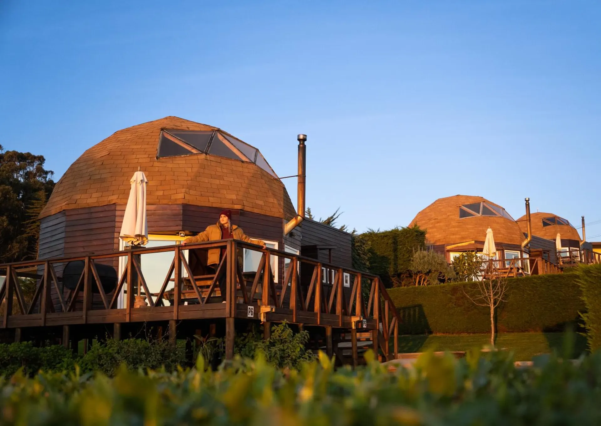 The domes at sunset, with a wooden playground on the grass.
